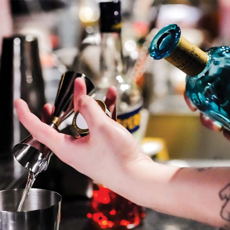 Closeup of a bartender’s hands pouring alcohol in a shaker at Gishiki Lounge, Hong Kong