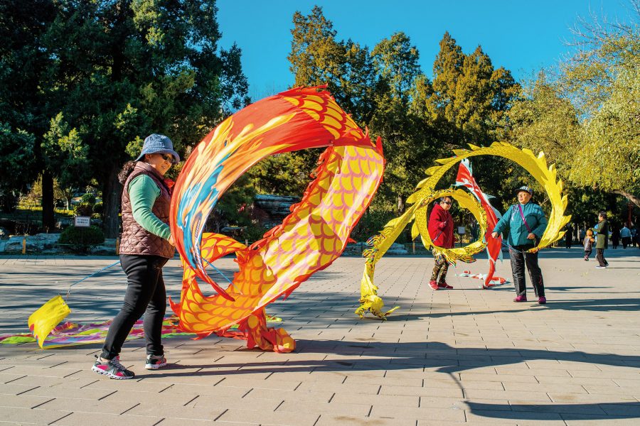 People swirling colourful dragon ribbons in Jingshan Park, Beijing.