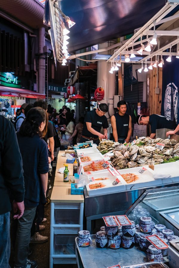 Staff and customers at a seafood stall in Omicho Market.