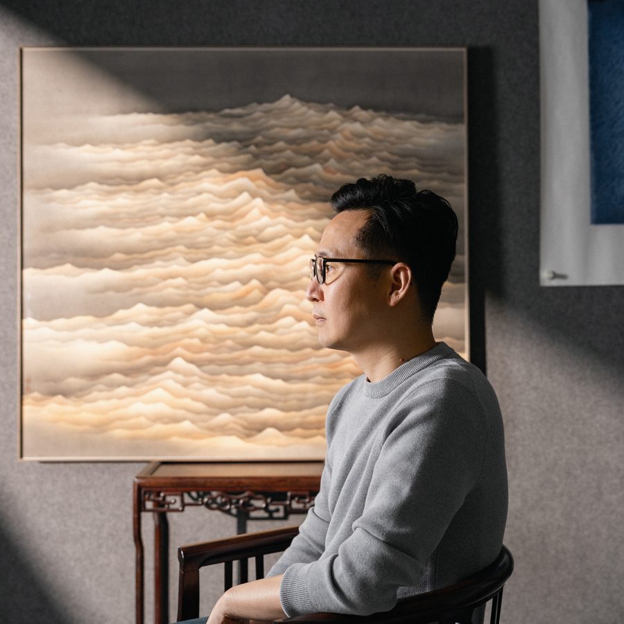 Chan Keng Tin sitting in front of his artworks