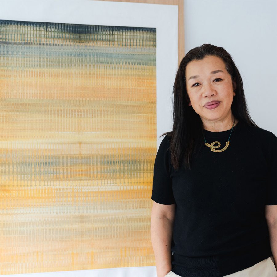 Fan Yan standing in front of her artworks
