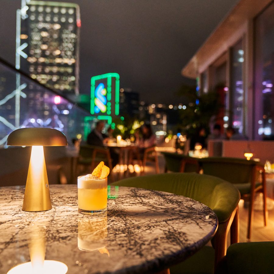 Cardinal Point’s outdoor seating area overlooks the glowing Victoria Harbour at night.