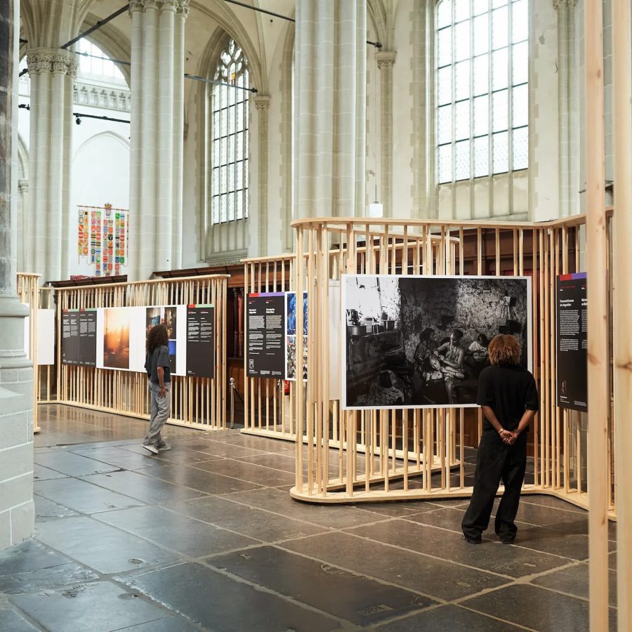 People looking at artwork inside Amsterdam’s De Nieuwe Kirk The New Church showcasing an exhibition of art photography 