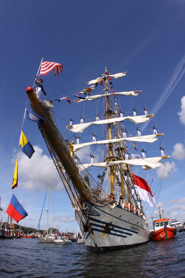 A view of a tall historic ship in the water seen from a low angle at IJ Harbour in Amsterdam, Netherlands during daytime