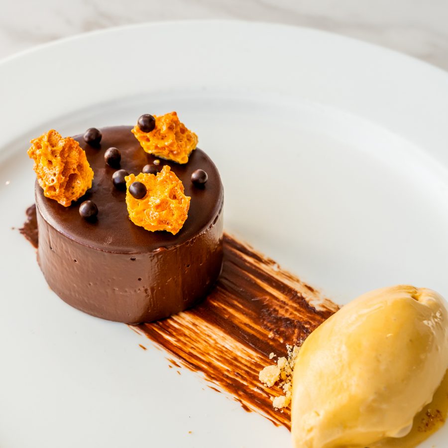 A chocolate dessert with ice cream on a white plate served at Harbourside Grill