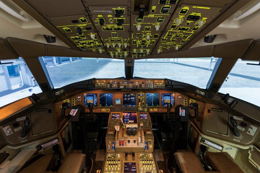 The cockpit of an aircraft reveals a large number of buttons, switches and displays. 