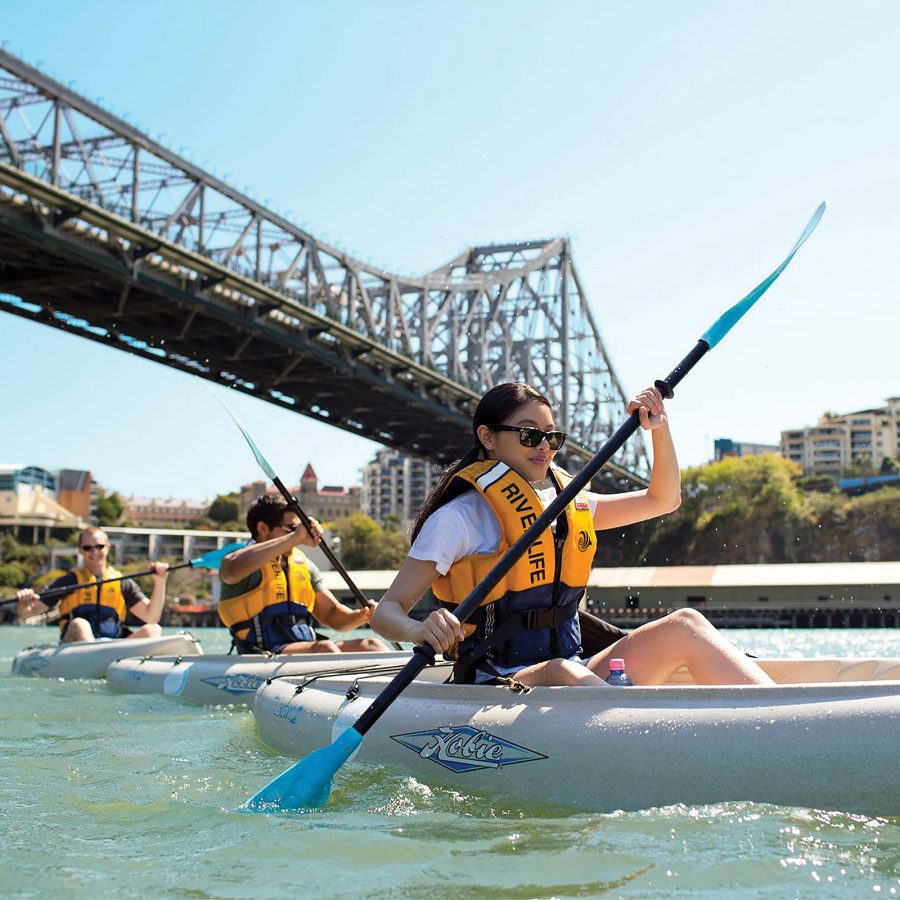 Participants of a Riverlife tour kayaking under Story Bridge on Brisbane River.