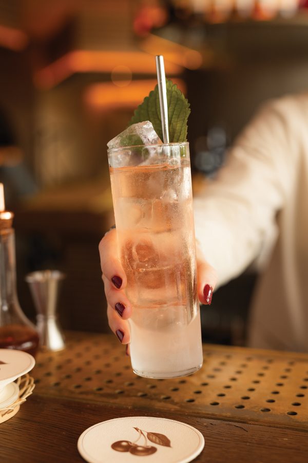 Close-up of a bartender hand’s holding a cocktail at Supernormal in Brisbane.
