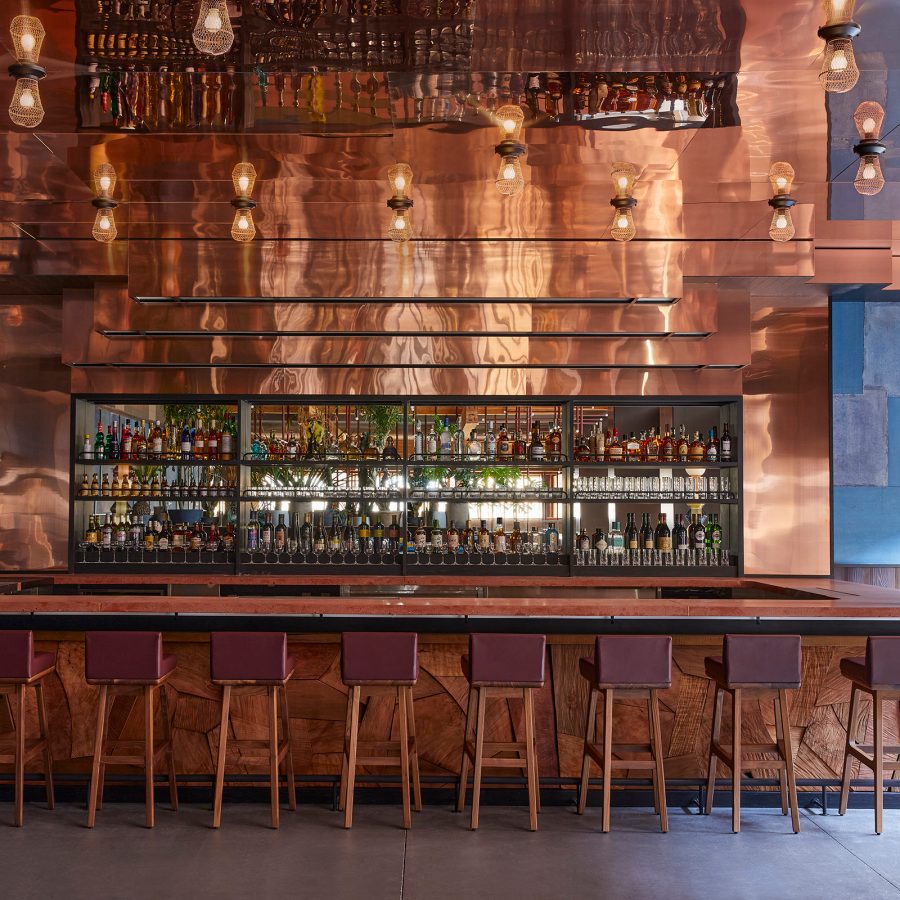 The bar and a row of chairs at Piopiko Bar and Taco Lounge in Ace Hotel Kyoto. 