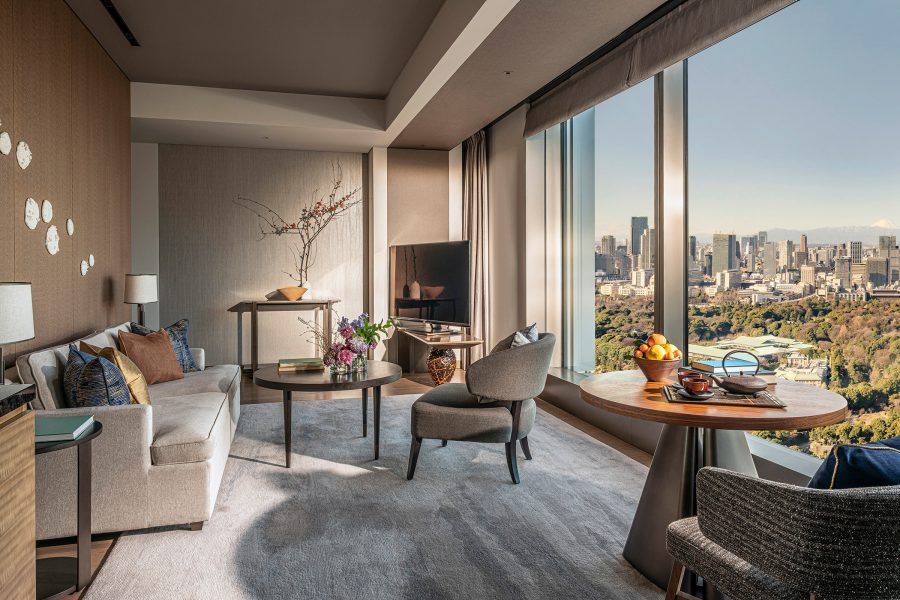 View of the living room area and floor-to-ceiling windows overlooking Tokyo at the Four Seasons Hotel Tokyo Otemachi.