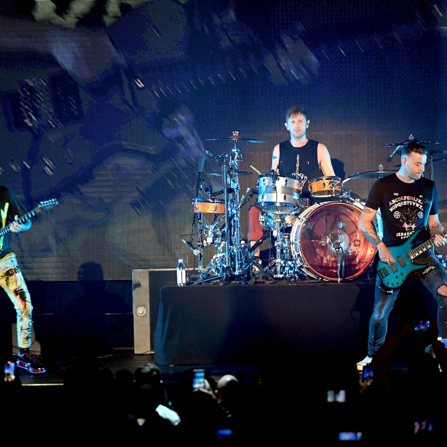 The members of Muse, who will be performing in Jakarta later this year, perform on stage with their respective instruments.