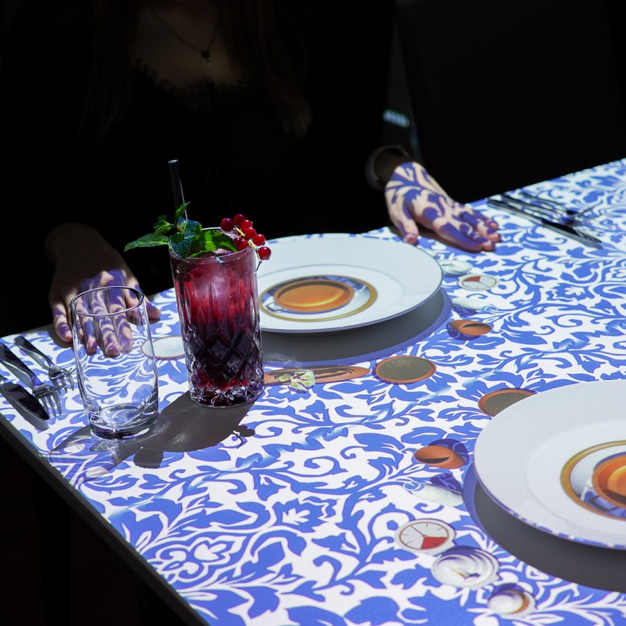  Interior view of two red cocktails and a 3D tabletop projection at Le Petit Chef. 