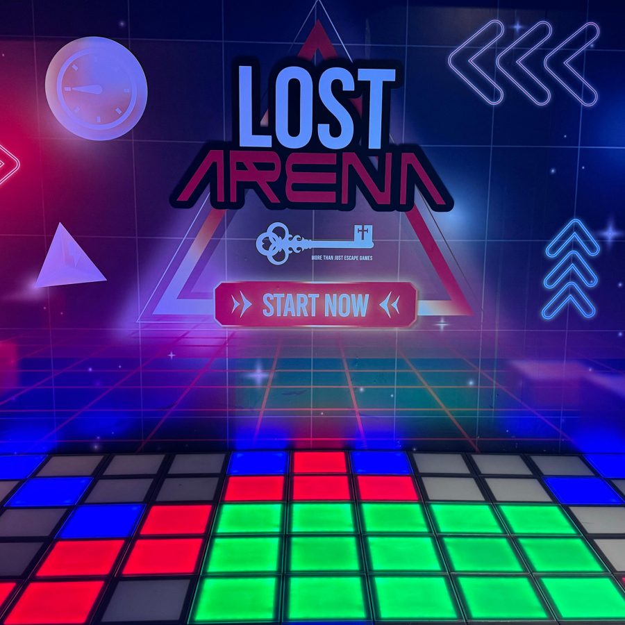 Interior view of Lost Arena, with coloured squares on the floor and writing and graphics on the back wall. 