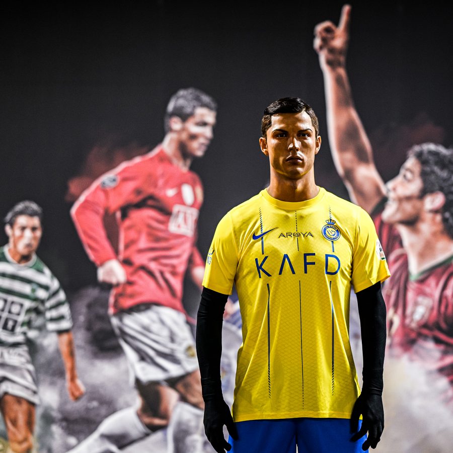 A model of Cristiano Ronaldo stands in front of collaged images of himself at the CR7 Life Museum.