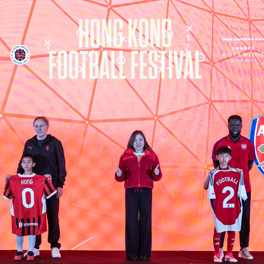People, including football players and children, stand on stage at the Hong Kong Football Festival.
