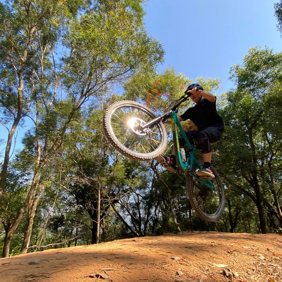 A person on a bike jumping on a dirt hill.