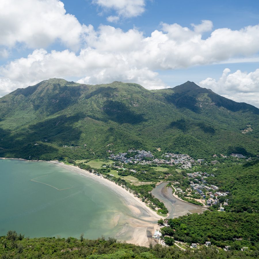 A body of water with mountains in the background in Lantau South Country Park. 