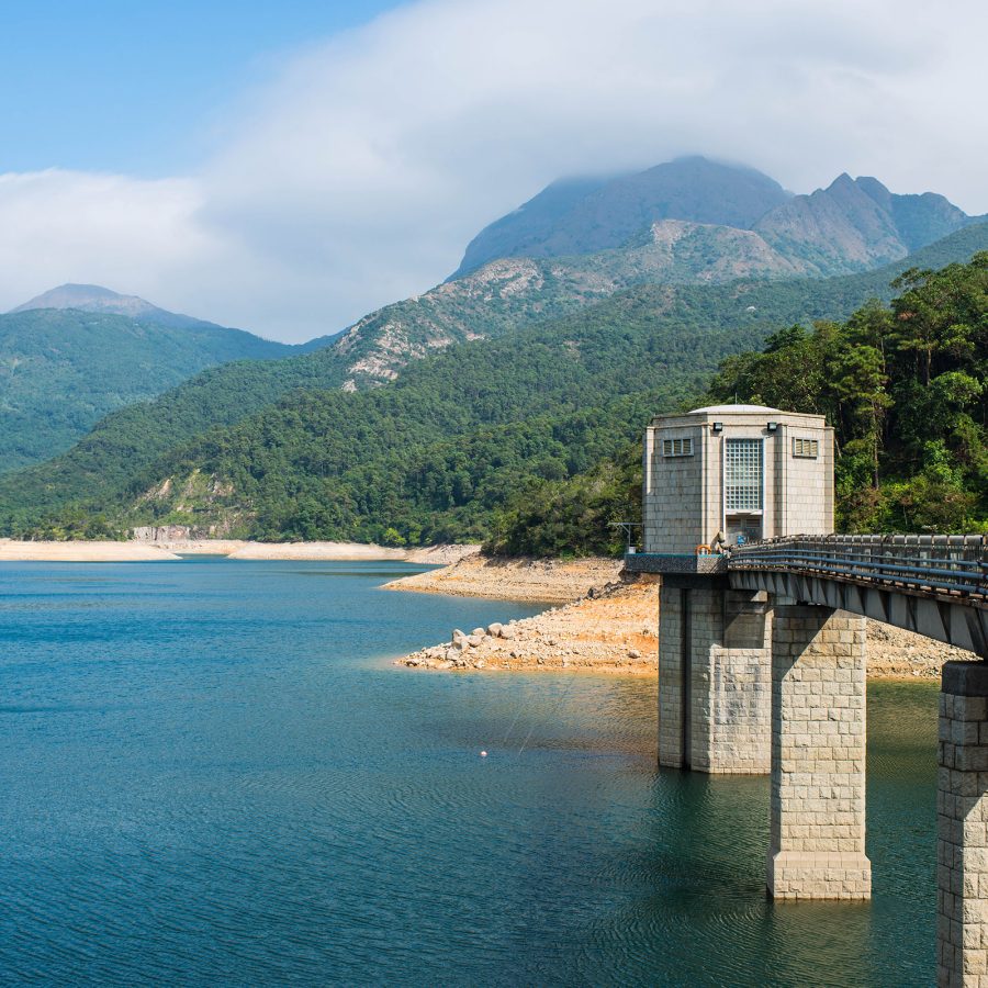 A bridge over water with mountains in the background in Lantau South Country Park. 