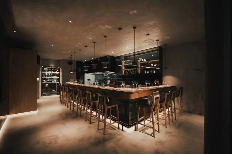 The interior of Flame Restaurant features an intimate bar area with bar stools for seating.