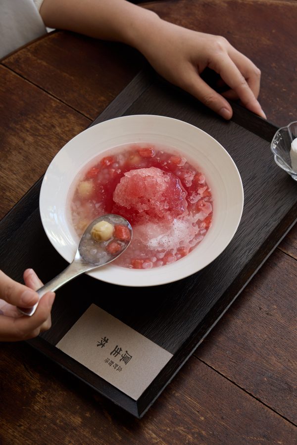 A person picks up a spoonful of pink sweet soup at Hau Sinn-Lim. 