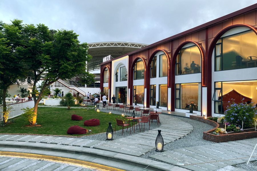  The exterior of Minnan Dayuan is a two-storey building with floor-to-ceiling windows next to a yard area.  