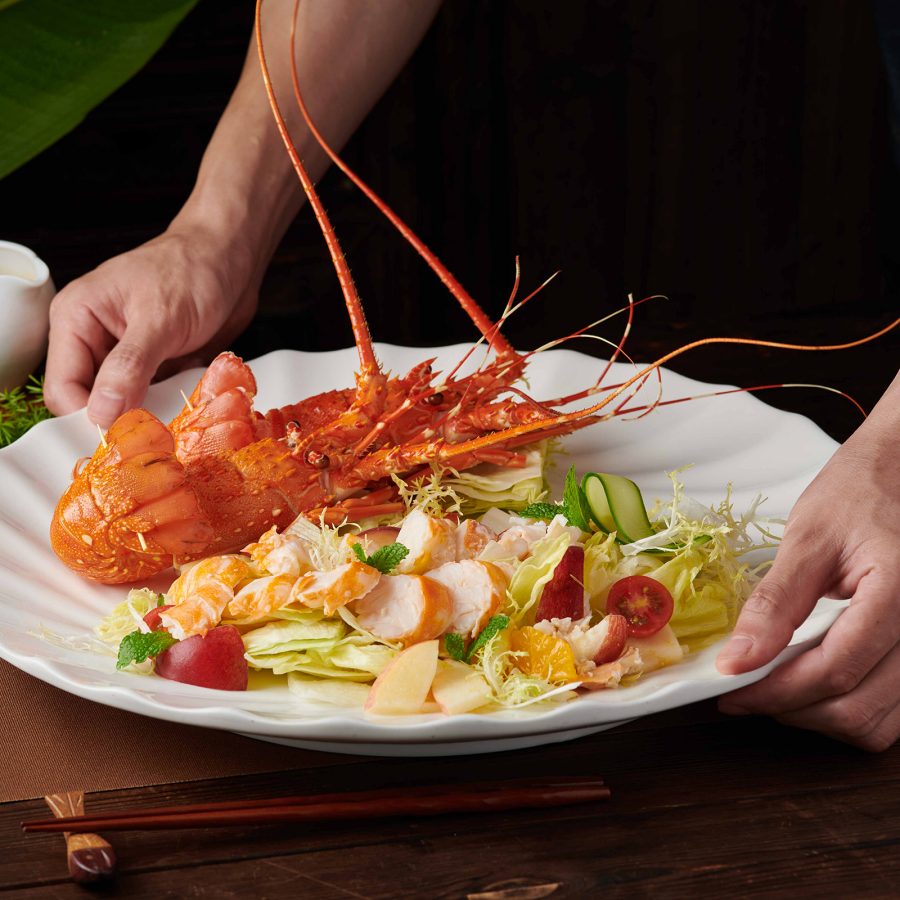 A whole lobster is plated next to salad at Minnan Dayuan.