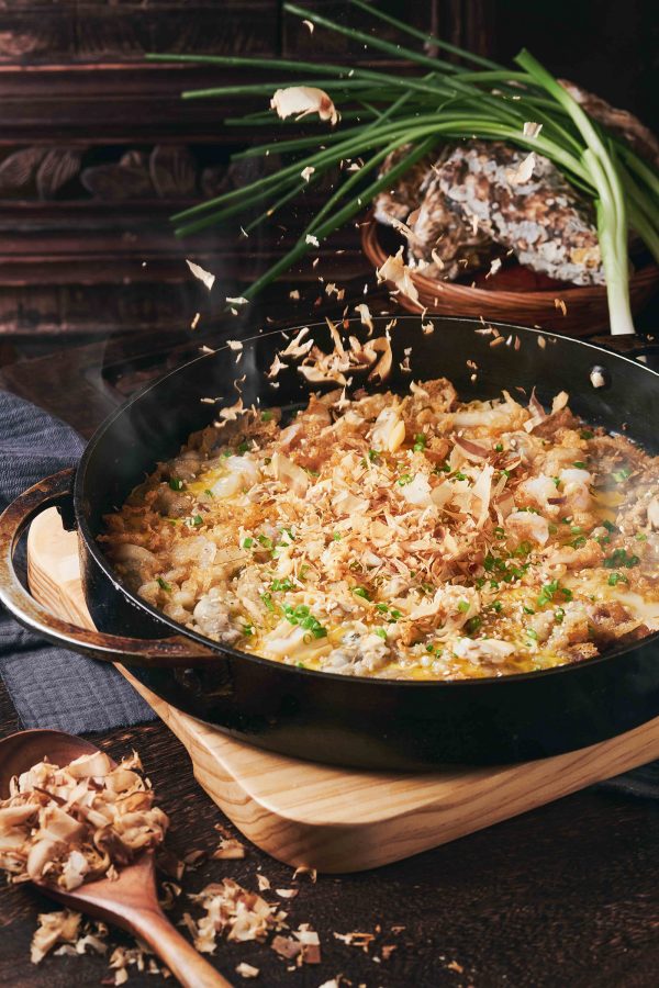 Bonito flakes are sprinkled onto an oyster pancake dish served on a skillet at Minnan Dayuan.