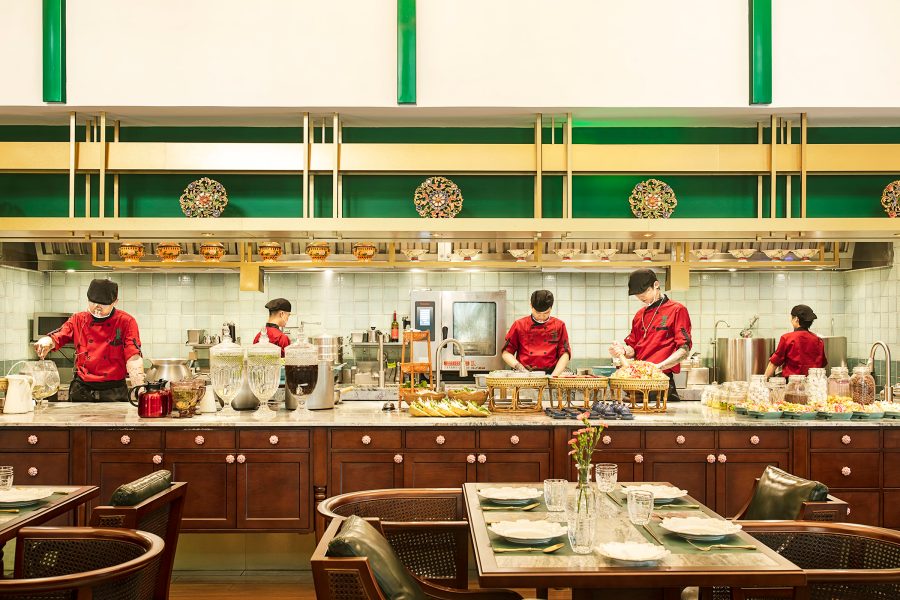 Chefs in red are seen behind a buffet bar and open kitchen at Queen Cheuk Yuet in Xiamen. 
