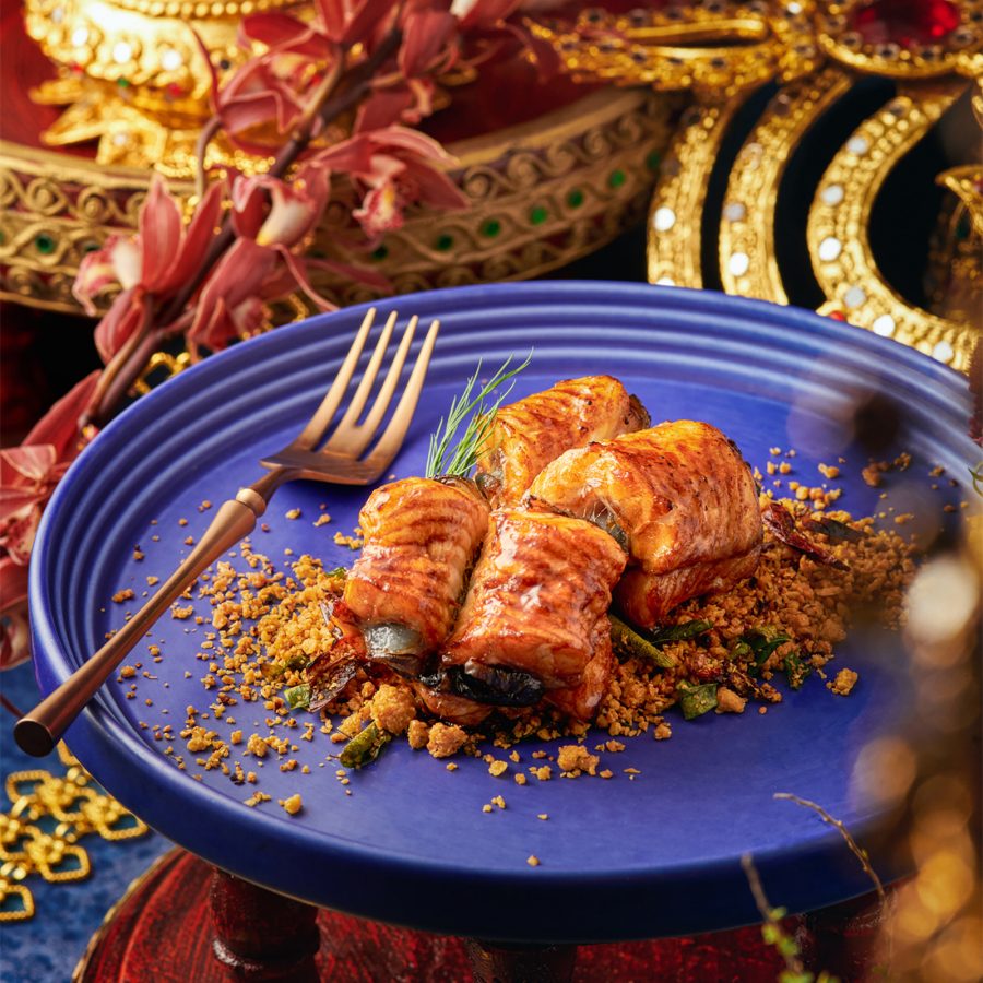A pastry is placed on a blue plate elevated on a stand at Queen Cheuk Yuet.   