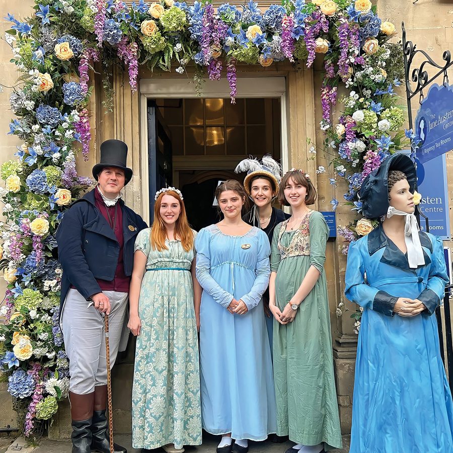 People in Regency costumes standing at the doorway of The Jane Austen Centre in Bath.
