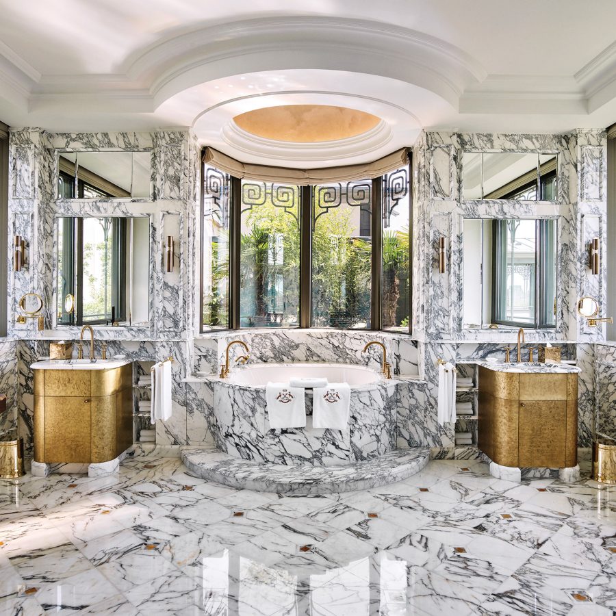The Belle Etoile suite at Le Meurice, Paris features a large marble-coated bathroom with a bathtub in the middle and two windows looking out over the city.    