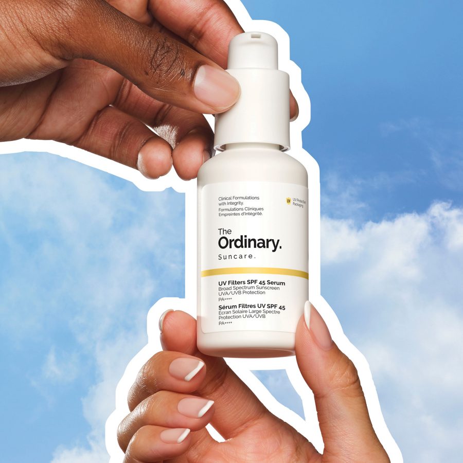Two hands holding a bottle of The Ordinary UV Filters SPF 45 Serum