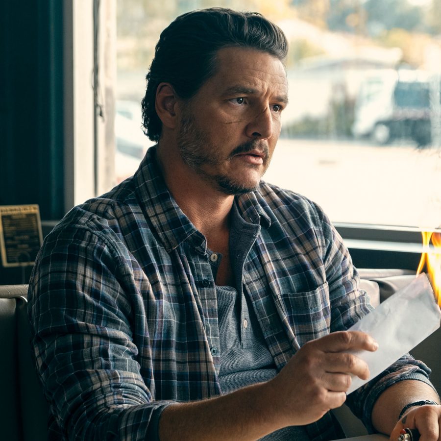 A man sits a restaurant table holding a piece of paper that is lit on fire, in a scene from the film Freaky Tales.