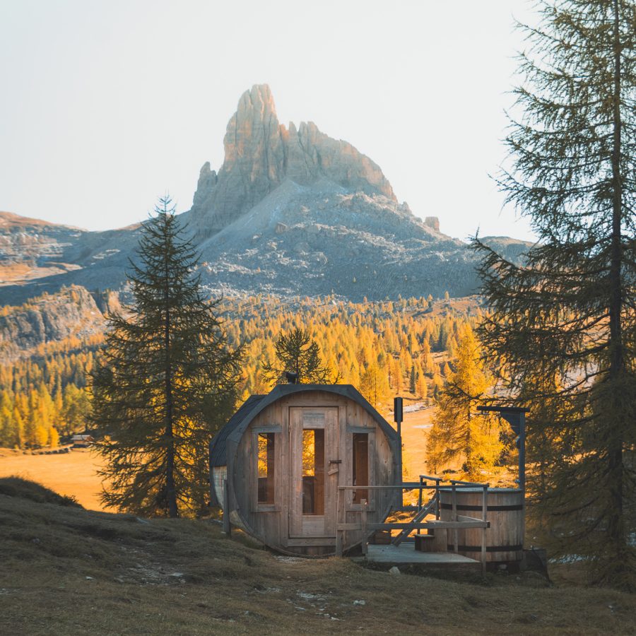 A small wooden sauna at Cotrina d’Ampezzo looks out at a mountain peak. 