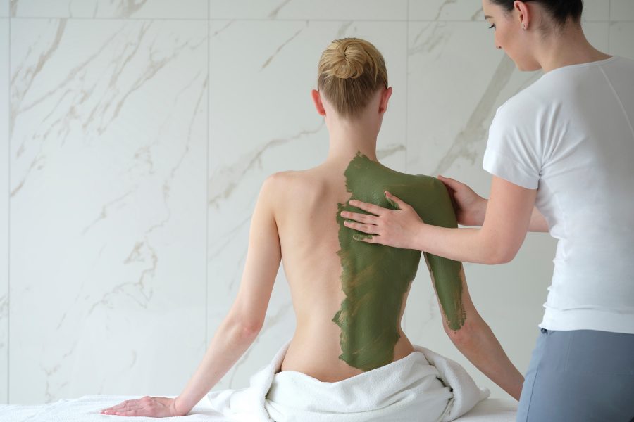 A female therapist applies a mud treatment to the back of a female guest at Chenot Palace Weggis.