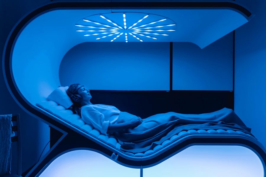 A woman relaxing in a blue-lit sauna at Revīvō Wellness Resort, Bali.