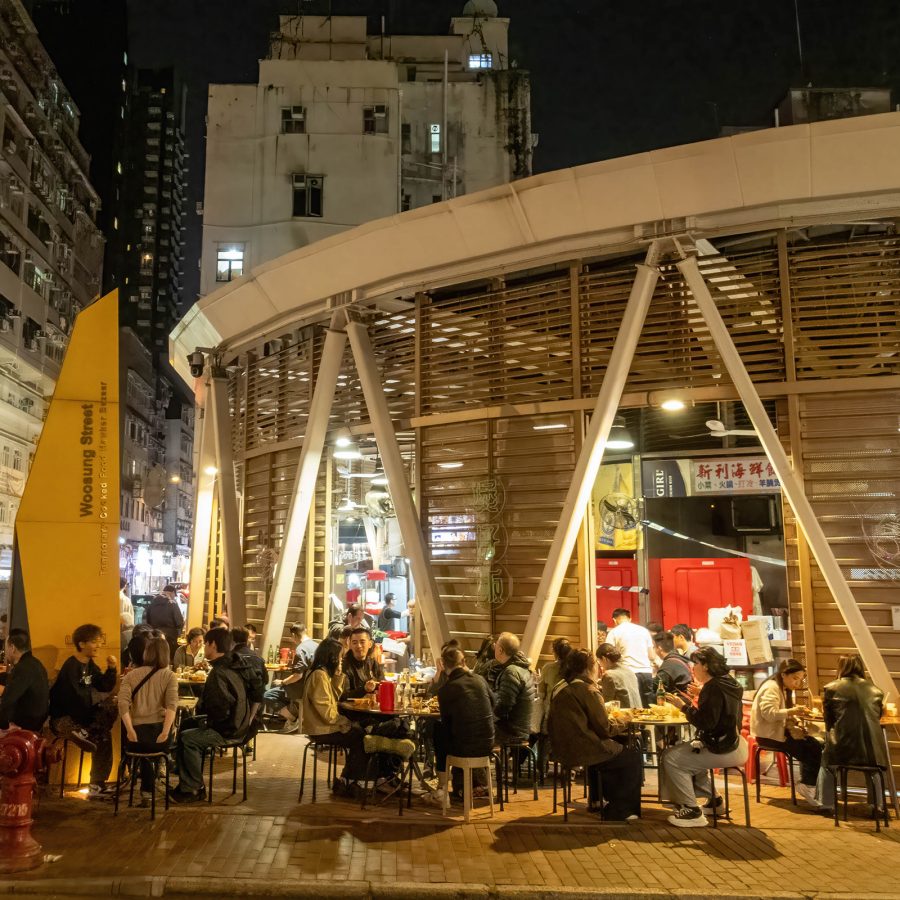 People gathered on tables outside Woosung Street Cooked Food Market. 