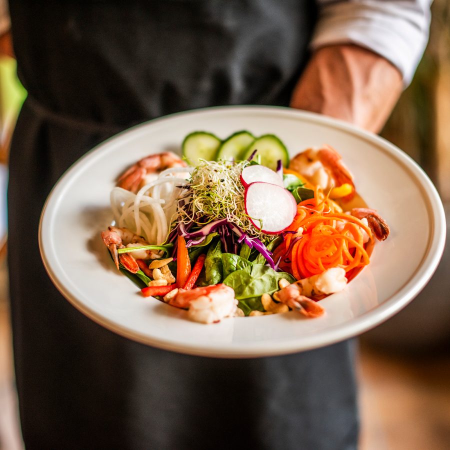Chef holds out a plate covered in vegetables at Mountain Trek Health Reset Retreat in Cana