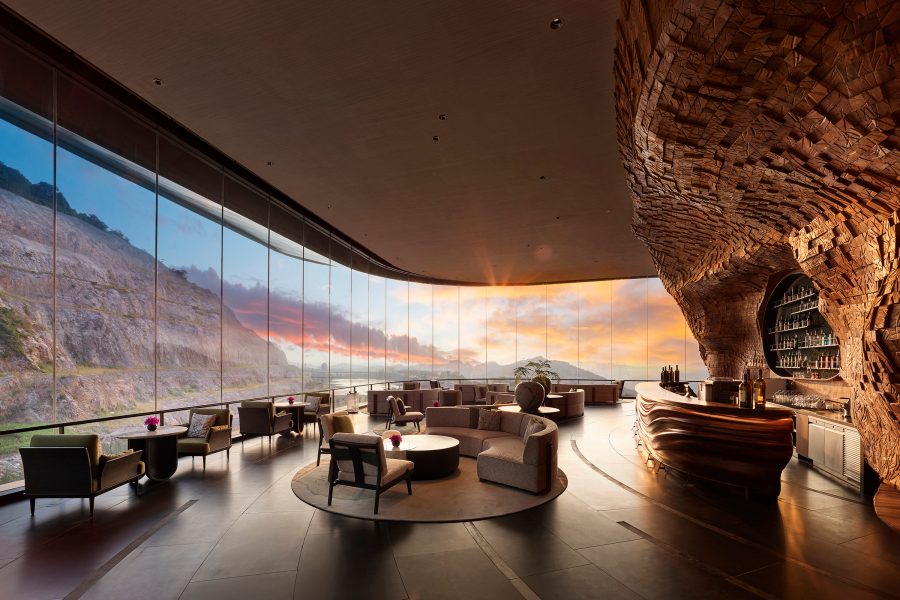 An interior view of the interiors of Banyan Tree Nanjing Garden Expo, featuring wraparound floor-to-ceiling windows and sunset in the backdrop 