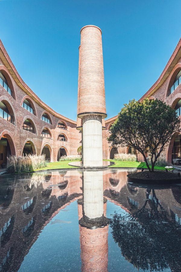 A view of a pond surrounded by red clay walls in the courtyard of DongFengYun Hotel Mi’Le in Yunnan Province Dongfengyun Art Town in China