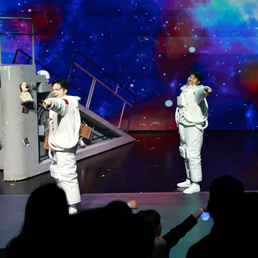 Three performers dressed in astronaut outfits point at the crowd at a performance at Macao Cultural Centre.