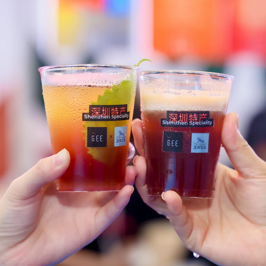 People clink two glass cups of coffee together at Shenzhen’s CAFEEX expo.