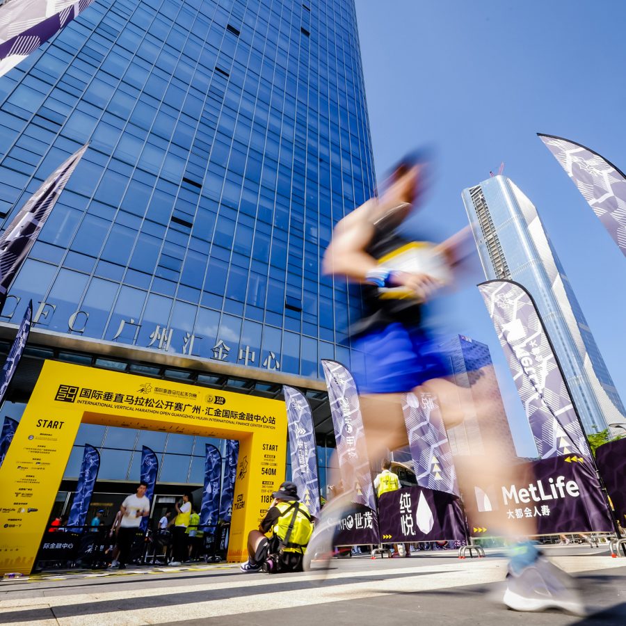 A person runs in a blur past a yellow starting line as part of the International Vertical Marathon Open in Guangzhou. 