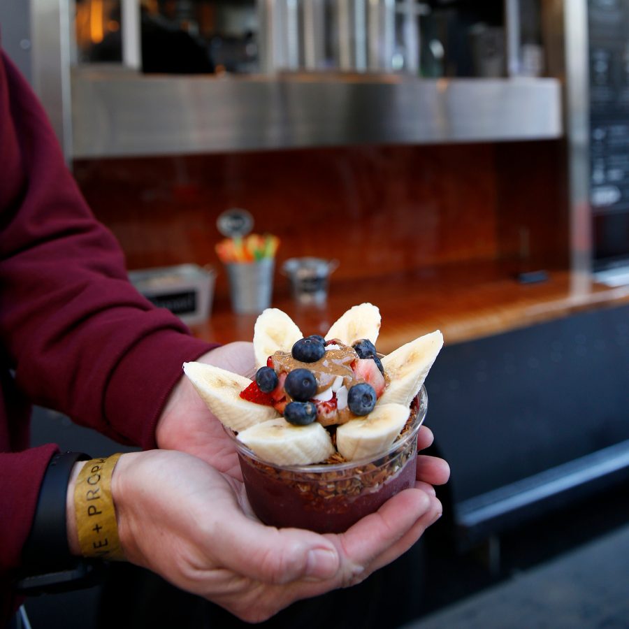 A person holding a cup of acai with blueberries, bananas and various ingredients from Bowl’d Acai in San Francisco 