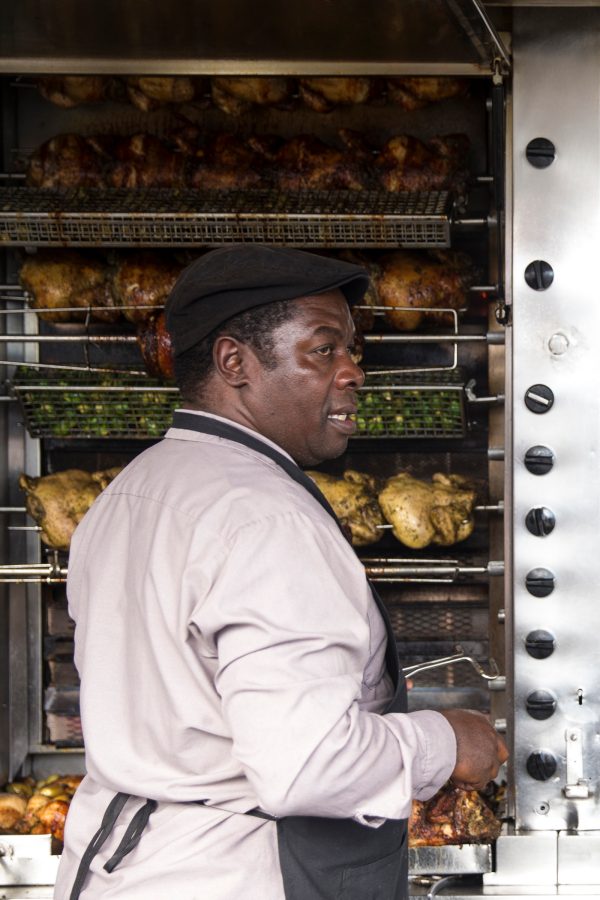 A chef at Roli Roti in San Francisco overseeing various meats on the rotisserie