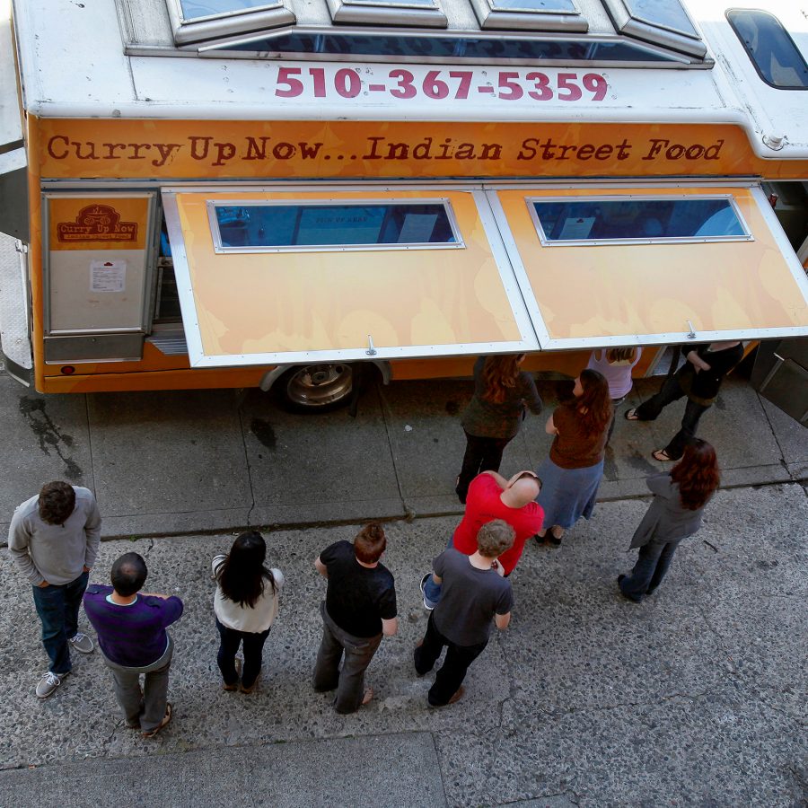 A topdown view of people queueing at Curry Up Now food truck, parked by a sidewalk in San Francisco 