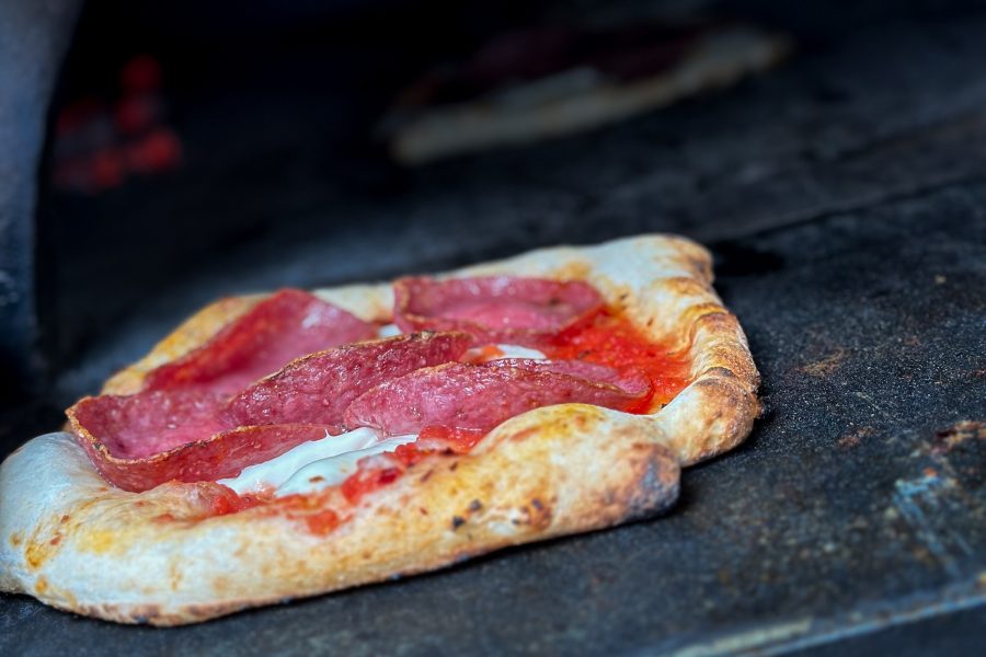 A close up of a pizza with cheese, tomato sauce and pepperoni toppings in an oven, served at Mozzeria in San Francisco 