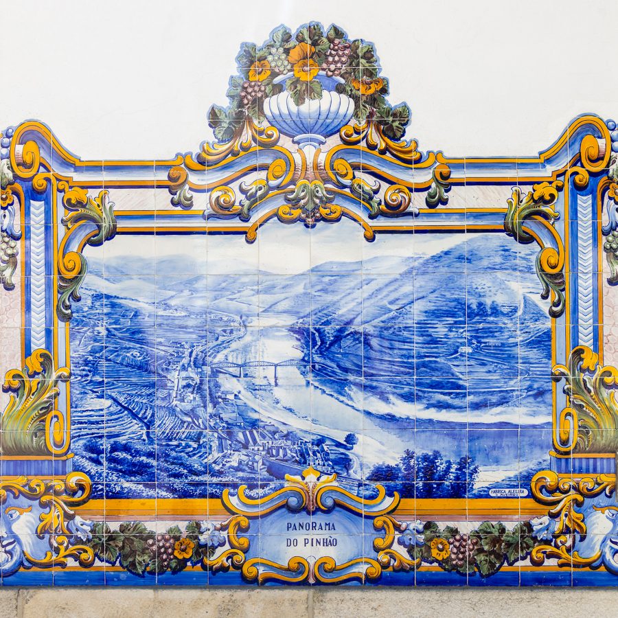 An artwork at Pinhao Station in Portugal, drawn over ceramic tiles in blue, shows an aerial view of a landscape.