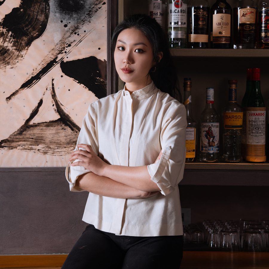 Ariel Hou standing behind the bar at Bar Pine in Taipei with her arms crossed. 