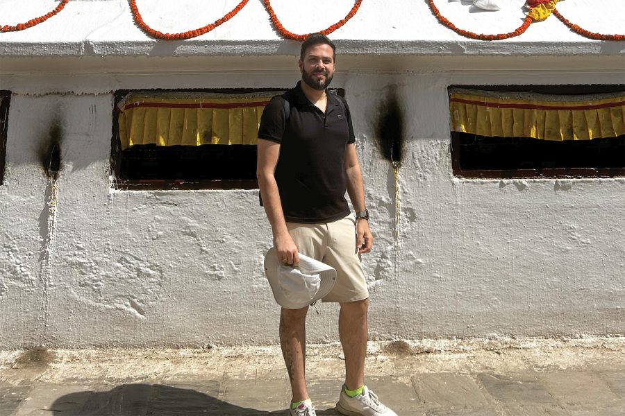 Cathay Pacific crew member Rishikesh Bhat stands in front of the white wall of the Boudhanath Stupa in Kathmandu